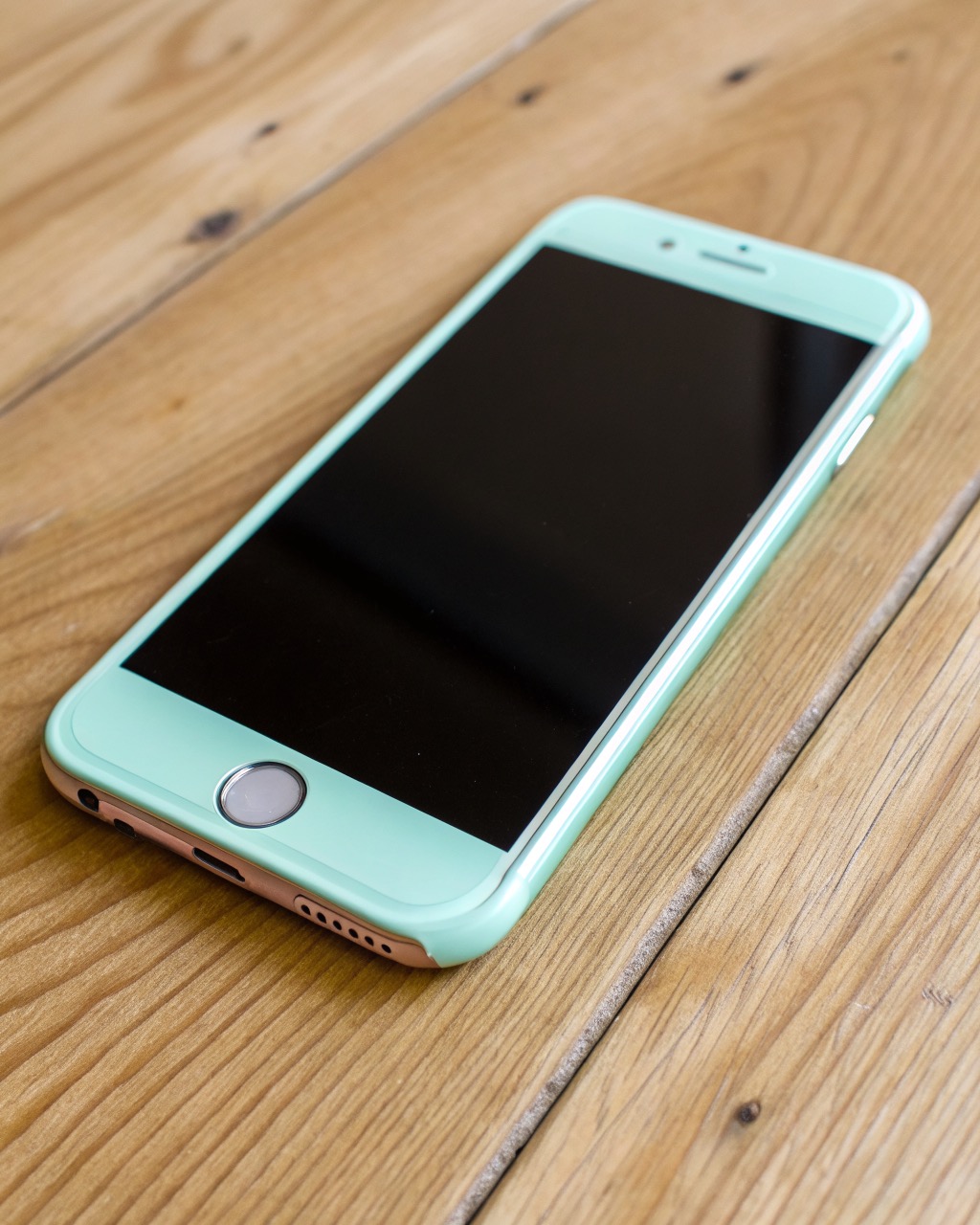 Mint-green plastic-back smartphone shown front and back, flat OLED screen, dual rear camera in a small square module, matte frame, no logos or brand marks