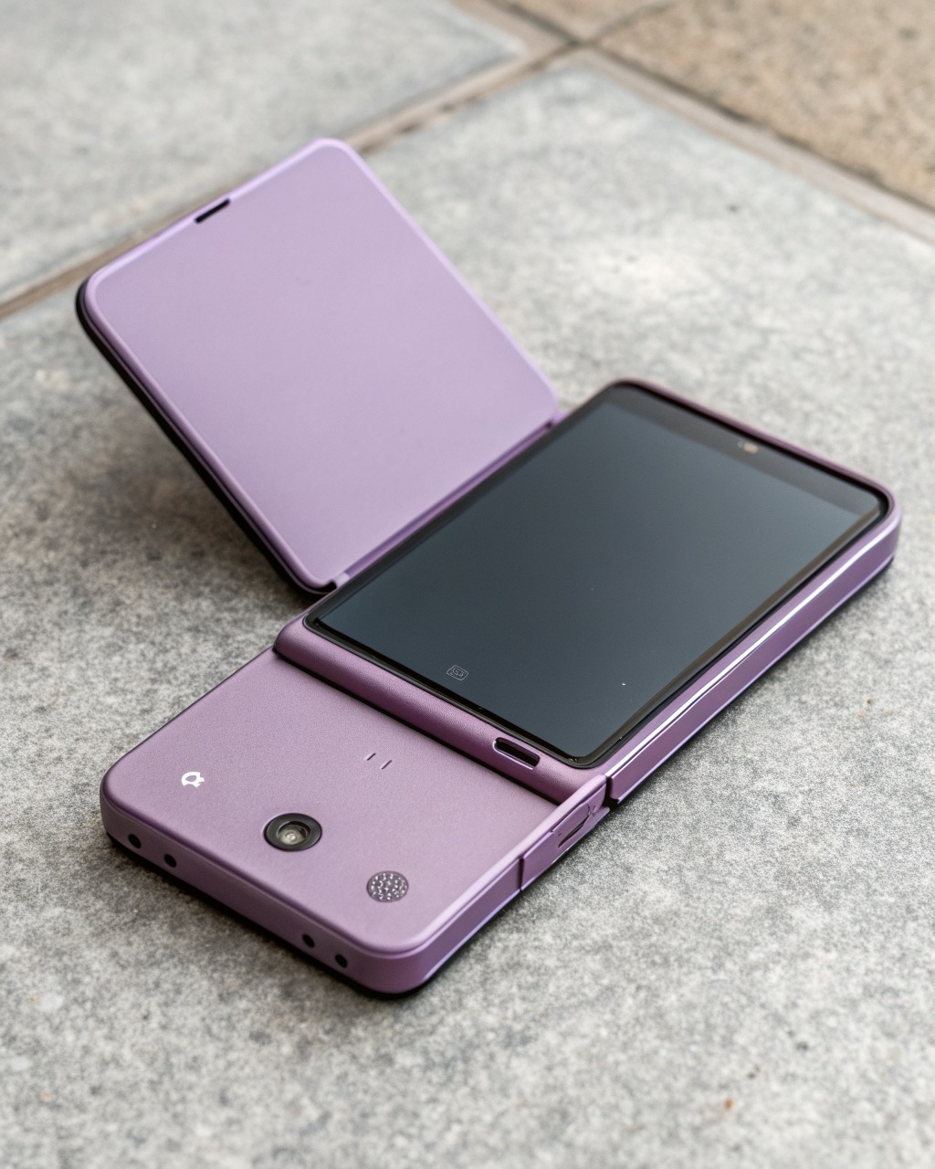 Lavender clamshell flip smartphone shown folded into a small square beside its open tall form, round cover screen, dual rear camera, no branding