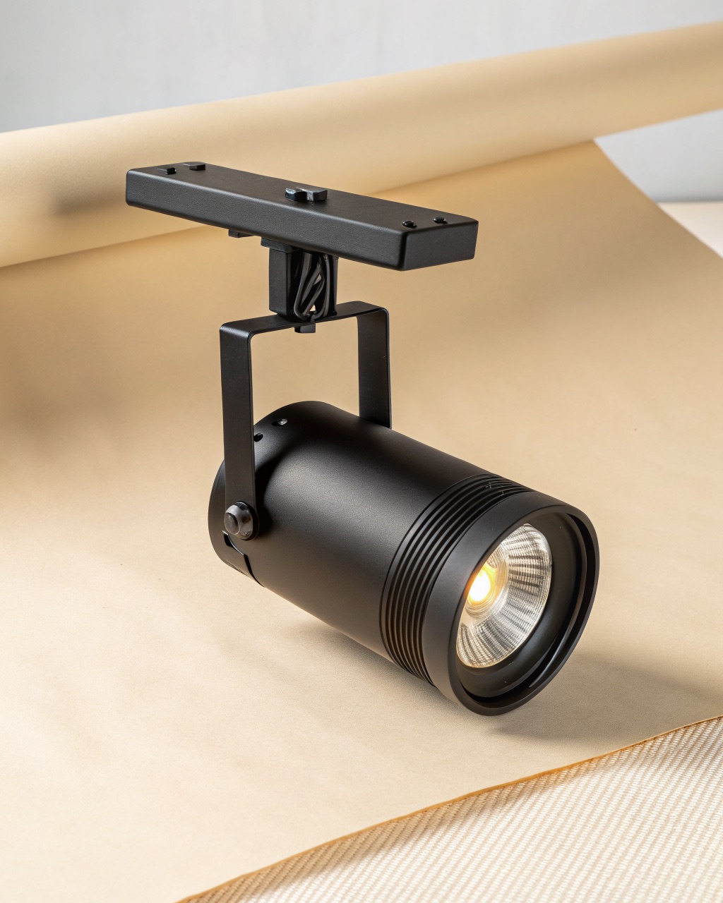 Single matte black die-cast aluminum track spotlight head with a cylindrical body and tilting yoke