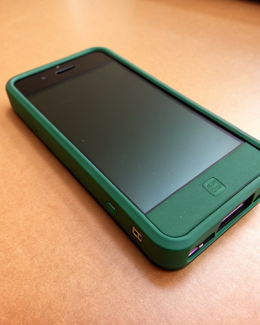 Thick deep-green smartphone shown front and three-quarter angle emphasizing its chunky body, dual rear camera, matte plastic back, no branding