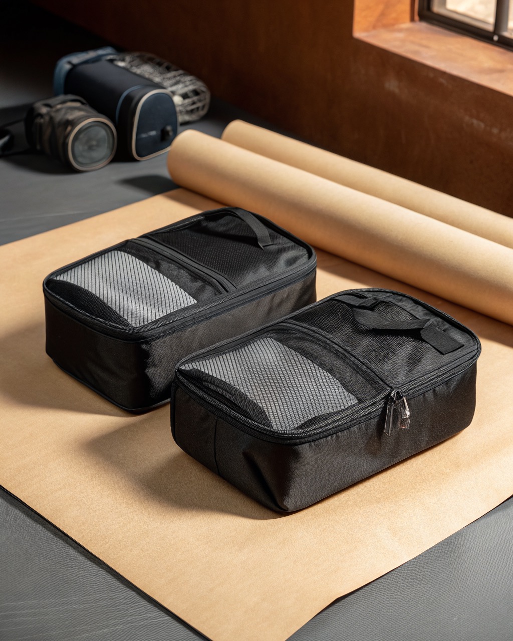 Pair of black coated-polyester travel shoe bags shown side by side with mesh ventilation panels and clear front windows on a plain surface