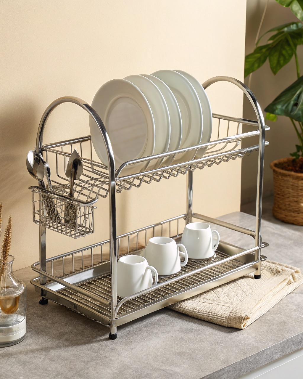 Tall two-tier stainless steel dish rack with plates on the lower shelf and cups on the upper shelf, two drip trays below
