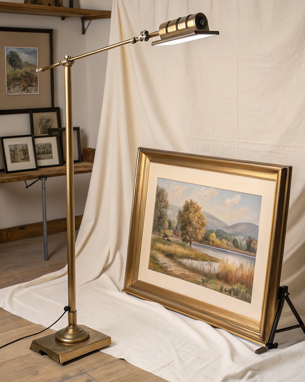 Slim brushed brass picture light bar mounted above a framed painting, angled down to wash light across the canvas